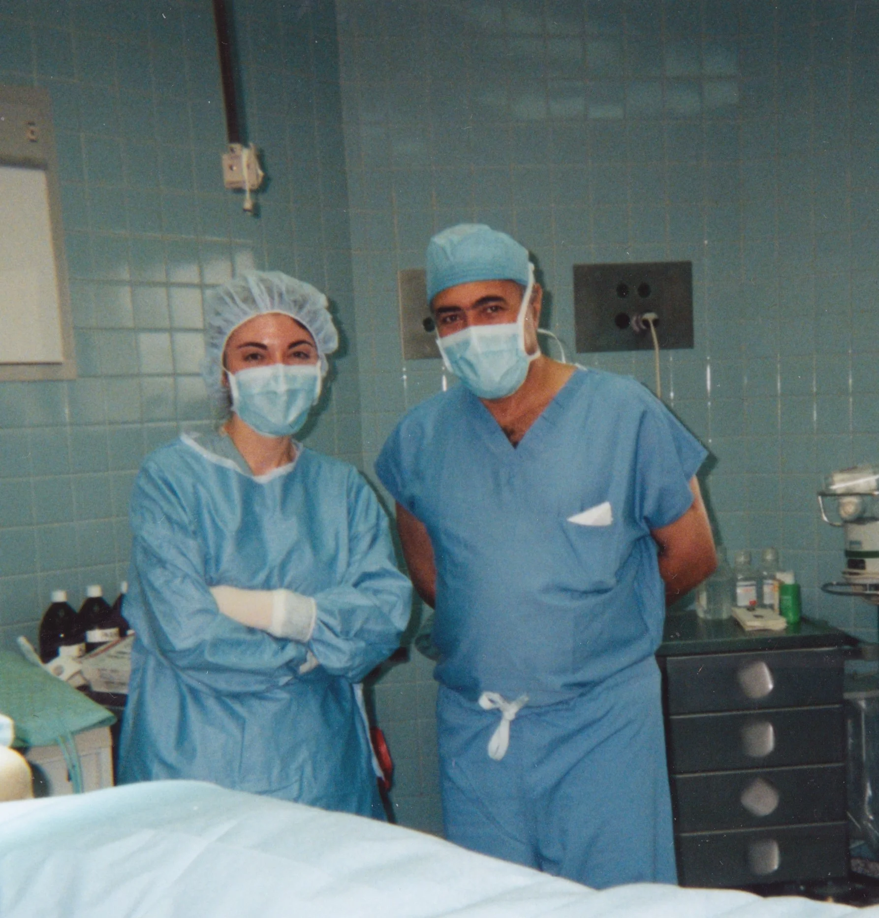 Two people in scrubs inside an operating room